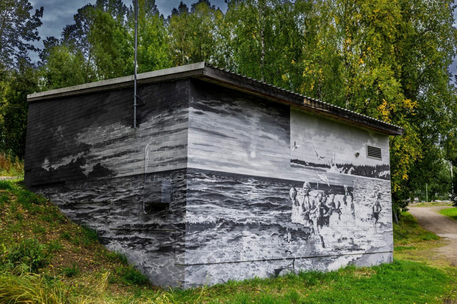 Tehdaskadun jätevedenpumppaamon muraaliteos, jossa on uimareita rannalla. Muraalin on maalannut Evgeni Ivanov.